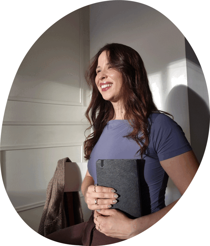 Sarah, fundadora da English Playbook, sorrindo com um notebook nas mãos
